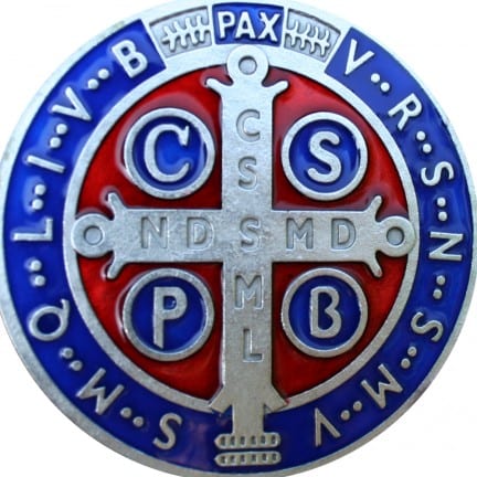 The enameled front face of a Saint Benedict Medal in blue and red, with cross and the initials C S S M L and N D S M D.