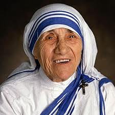 Close-up photograph of Saint Teresa of Calcutta smiling, wearing the white and blue-striped Missionaries of Charity sari.