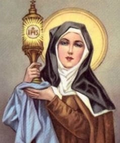 Devotional holy card of Saint Clare of Assisi in brown and blue habit with white veil, holding a golden monstrance.